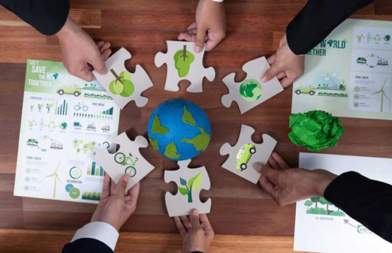top-view-cohesive-group-business-people-holding-eco-icon-jigsaw-puzzle-pieces-around-globe-earth-as-eco-corporate-responsibility-community-sustainable-solution-greener-earth-quaint-870x563